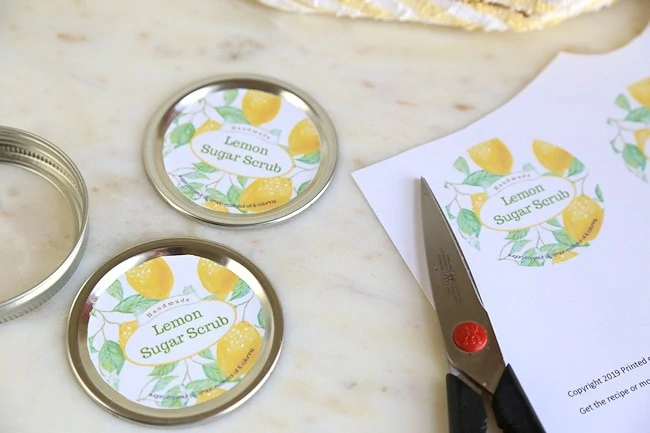 gluing lemon sugar scrub labels on caps