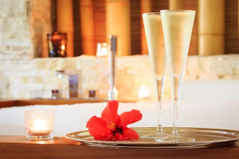 champagne and flowers on tray with candle