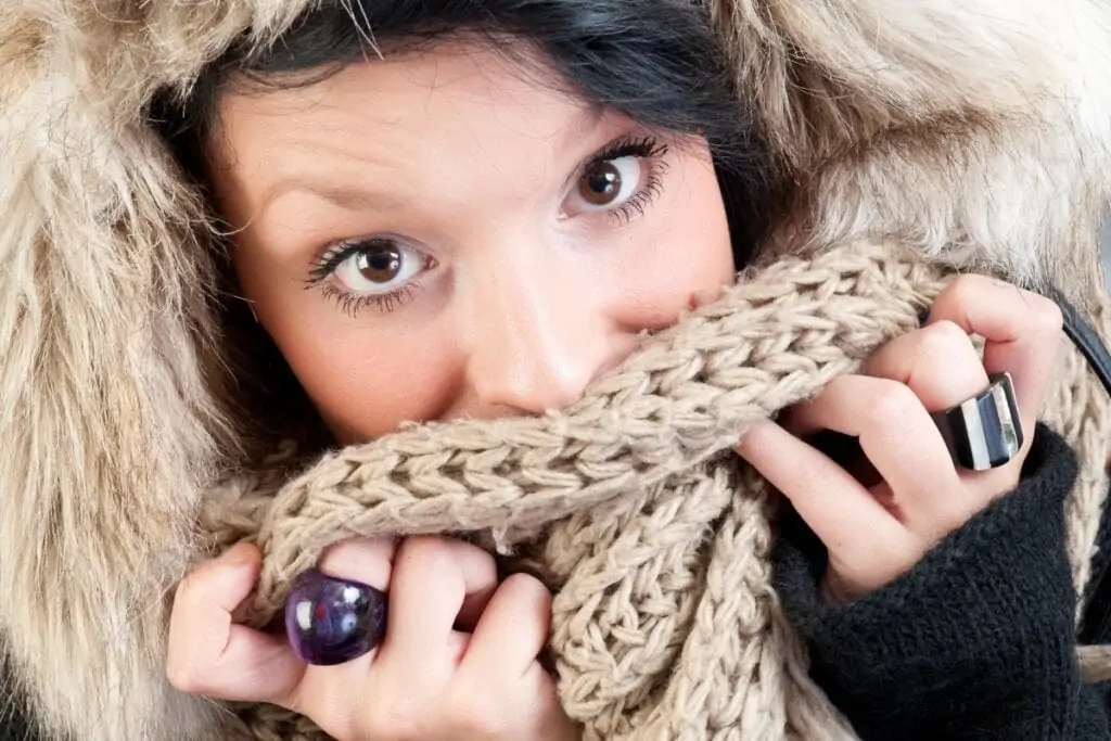 harsh winter weather, woman covering her lips from cold with scarf