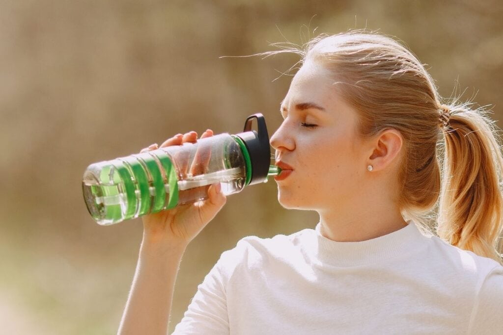stay hydrated, woman drinking from water bottle