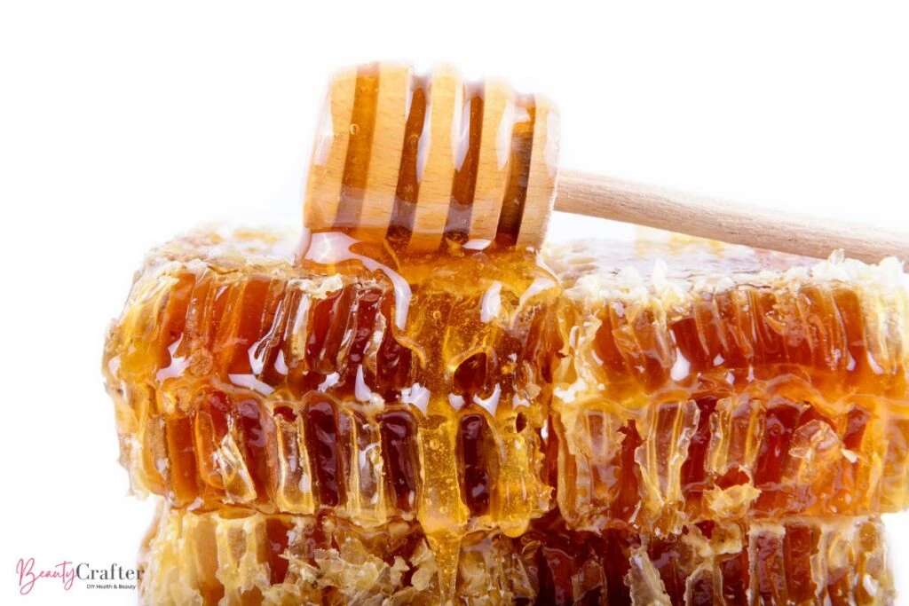 A close-up of a honeycomb with raw honey oozing out, showcasing the natural humectant properties of honey for hair